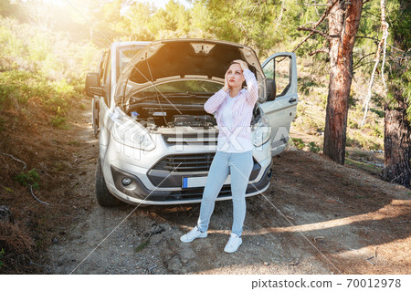 Woman is waiting desperately with open car hood for support of troubleshoot automobile. Transportation and vehicle concept. Woman is waiting desperately with open car hood for support of troubleshoot automobile. Transportation and vehicle concept. 70012978