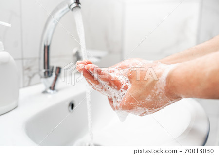 Personal hygiene, cleaning hands with soap often on faucet to protect from virus. 70013030