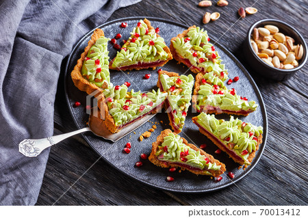 Pistachio ganache tart with pomegranate, top view Pistachio ganache tart with pomegranate, top view 70013412