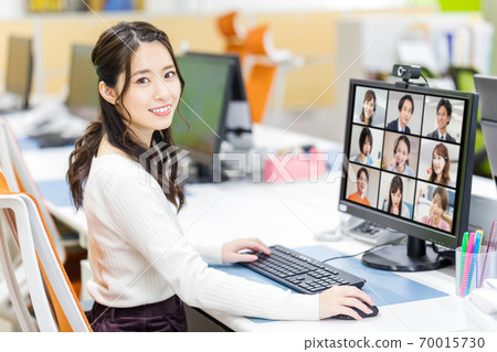 Female employees holding remote meetings in the office Female employees holding remote meetings in the office 70015730