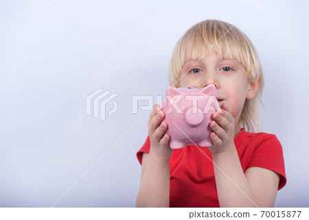 Cute blond boy holding piggy Bank. Money Saving Concept. Cute blond boy holding piggy Bank. Money Saving Concept. 70015877