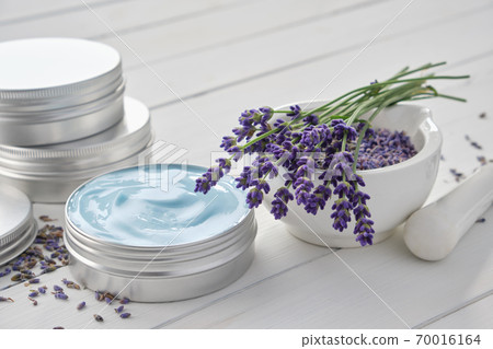 Natural organic lavender cream, mortar and bunch of dry lavender flowers on white wooden table. 70016164