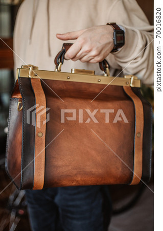 Business man holding elegant brown leather briefcase. Business man holding elegant brown leather briefcase. 70016820