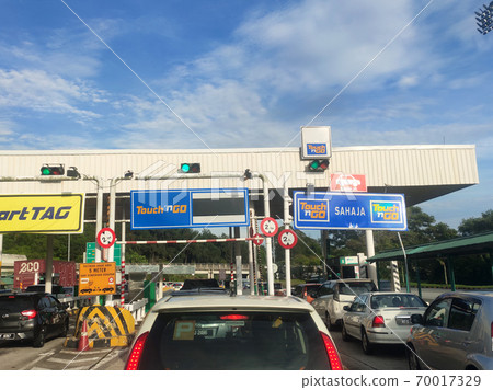 SEREMBAN, MALAYSIA -AUGUST, 2020: Vehicles entering highway toll canopy in Malaysia. Vehicles that use the expressway through a toll plaza and make payments each time they enter and exit. 70017329