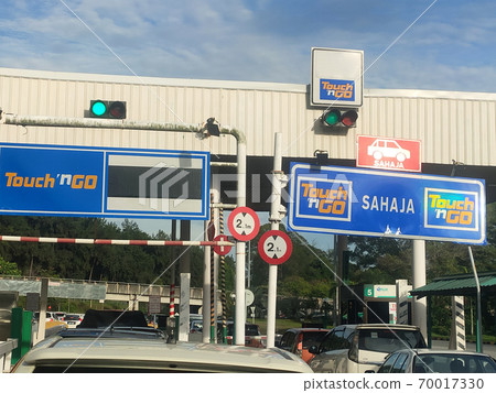 SEREMBAN, MALAYSIA -AUGUST, 2020: Vehicles entering highway toll canopy in Malaysia. Vehicles that use the expressway through a toll plaza and make payments each time they enter and exit. 70017330
