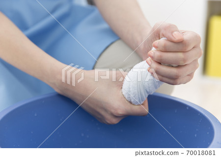 A woman's hand squeezing a rag A woman's hand squeezing a rag 70018081