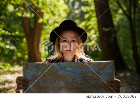 young caucasian woman in a hat looking at a geographic map young caucasian woman in a hat looking at a geographic map 70019362