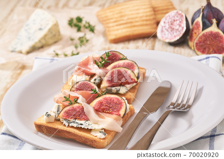 two sandwiches for breakfast with blue cheese ham and fresh figs. 70020920