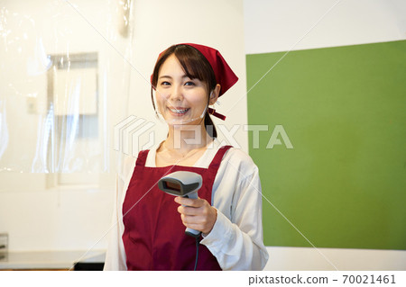 A clerk standing in a store with a vinyl partition 70021461