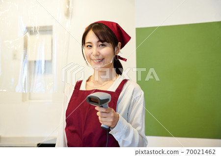 A clerk standing in a store with a vinyl partition 70021462