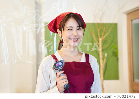 A clerk standing in a store with a vinyl partition A clerk standing in a store with a vinyl partition 70021472