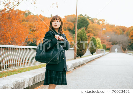 High school girl walking in the autumnal city 70023491