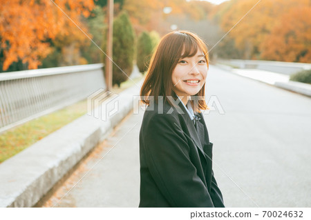 High school girl illuminated by the setting sun High school girl illuminated by the setting sun 70024632