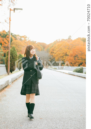 High school girl walking in the autumnal city 70024710