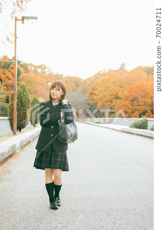 High school girl walking in the autumnal city 70024711