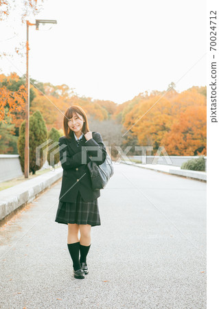 High school girl walking in the autumnal city High school girl walking in the autumnal city 70024712