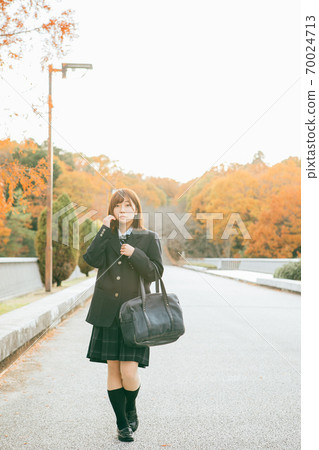 High school girl walking in the autumnal city 70024713