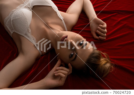 Ecstatic young woman on red look at camera 70024720