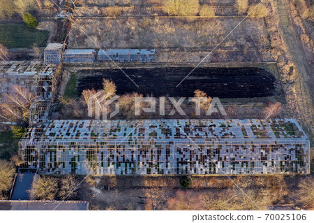 Abandoned derelict industrial greenhouse ruins in autumn, aerial 70025106