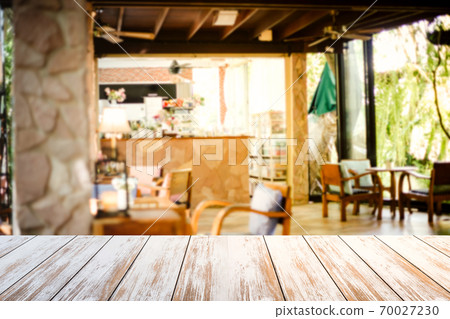 Old style white wooden table in coffee shop blurred background.Warm tones 70027230