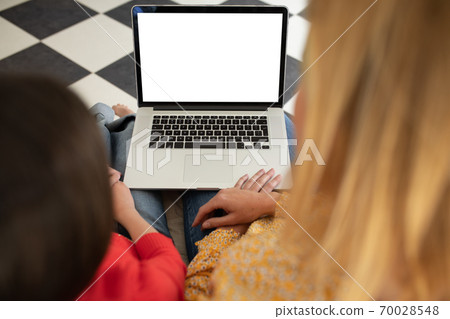Mother and daughter using laptop at home 70028548
