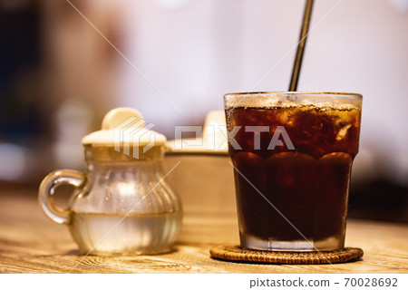 Woodgrain table with iced coffee, gum syrup and sugar 70028692