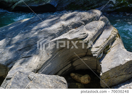 Rock pavement pothole eroded in a circle by the clear stream c 70030248