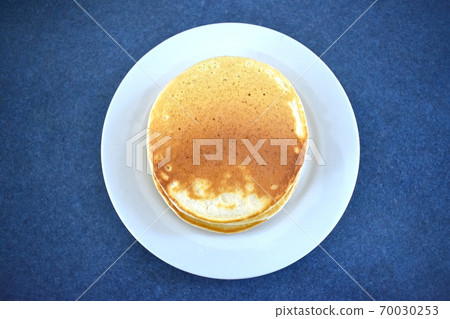 A stack of three pancakes on a plate 70030253