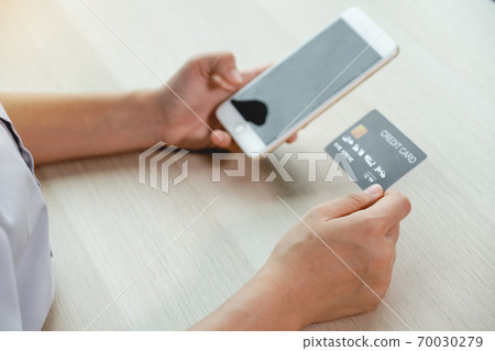 Businessman hand hold credit card to online shopping on smartphone from home, payment e-commerce, internet banking, spending money for next holidays Businessman hand hold credit card to online shopping on smartphone from home, payment e-commerce, internet banking, spending money for next holidays 70030279
