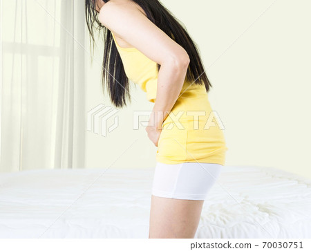 Young upset unhappy woman suffering from menstruation pain, PMS at home. Abdomen and stomach pain during criticals days. Health problems 70030751