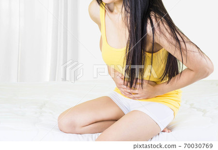 Young upset unhappy woman suffering from menstruation pain, PMS at home. Abdomen and stomach pain during criticals days. Health problems Young upset unhappy woman suffering from menstruation pain, PMS at home. Abdomen and stomach pain during criticals days. Health problems 70030769