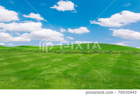 green field and blue sky with light clouds,Image of green grass field and bright blue sky. Plain landscape background for summer poster. green field and blue sky with light clouds,Image of green grass field and bright blue sky. Plain landscape background for summer poster. 70030943