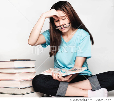 Beautiful asian female students during the exam Stay home and stressful and lazy reading books Beautiful asian female students during the exam Stay home and stressful and lazy reading books 70032556