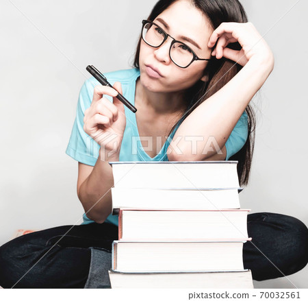 Beautiful asian female students during the exam Stay home and stressful and lazy reading books Beautiful asian female students during the exam Stay home and stressful and lazy reading books 70032561