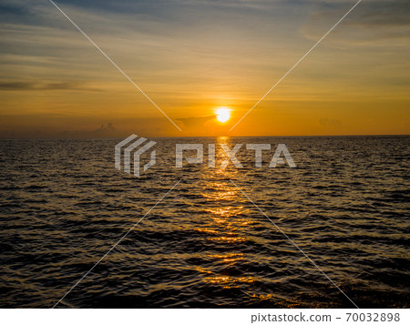 The golden reflection on the water surface from sunset is beautiful The golden reflection on the water surface from sunset is beautiful 70032898