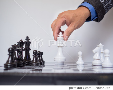 Businessman hand moving king chess piece on board with white background, challenges planning business strategy to success concept 70033046
