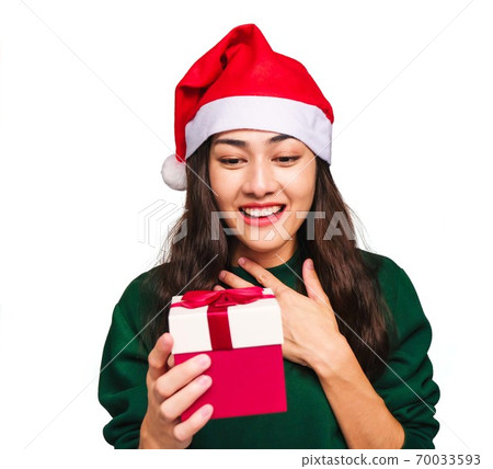Selective focus Young beautiful asian woman wore green sweater and santa hat,Excited, surprised and happy, Holding a gift box with a bow isolated on white background,Christmas day and New Year's gifts Selective focus Young beautiful asian woman wore green sweater and santa hat,Excited, surprised and happy, Holding a gift box with a bow isolated on white background,Christmas day and New Year's gifts 70033593