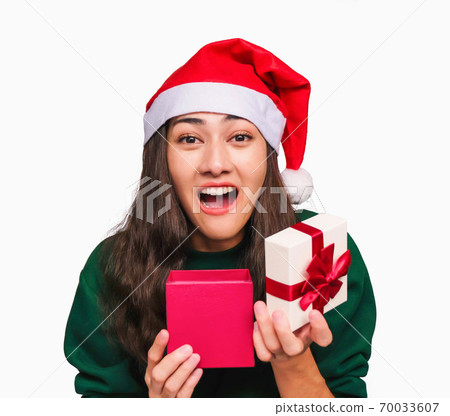 Selective focus Young beautiful asian woman wore green sweater and santa hat,Excited, surprised and happy, Holding a gift box with a bow isolated on white background,Christmas day and New Year's gifts 70033607