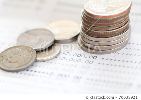 Selective focus of Thai's coins stacked over page of Bank account statement on white background, Collecting money for investment concept with copy space Selective focus of Thai's coins stacked over page of Bank account statement on white background, Collecting money for investment concept with copy space 70035921