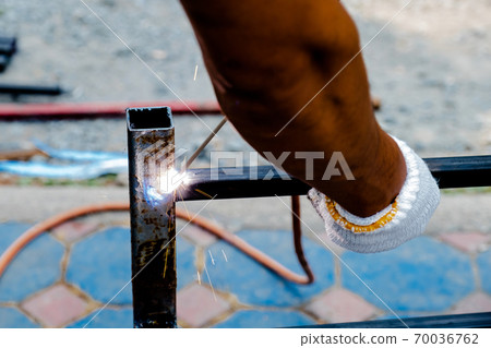 The mechanic is using a welding machine to weld steel The mechanic is using a welding machine to weld steel 70036762