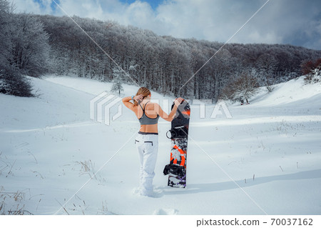 Female snowboarder hold snowboard and going to snowboarding Female snowboarder hold snowboard and going to snowboarding 70037162