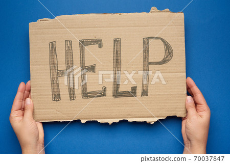 hand holds a piece of cardboard with the inscription help, mutual assistance concept 70037847