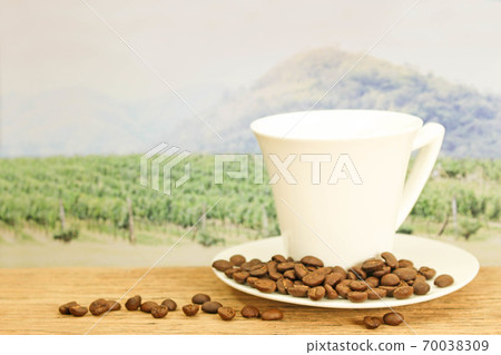 a cup of coffee with coffee seeds on wood in the a cup of coffee with coffee seeds on wood in the 70038309