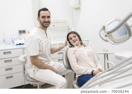 Portrait of a male dentist and young happy female 70039244