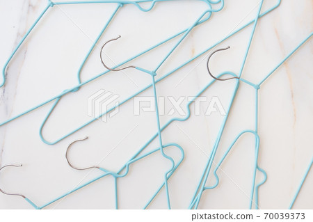 Shopping concept. A set of empty hangers await a wardrobe update. Buying new clothes, changing your image. Blue clothes hangers on white background 70039373