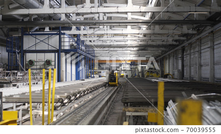 Modern Aluminium extrusion production line in factory. Production of Complex lightweight extruded aluminium metal profiles, commonly used as material in construction and manufacturing Modern Aluminium extrusion production line in factory. Production of Complex lightweight extruded aluminium metal profiles, commonly used as material in construction and manufacturing 70039555