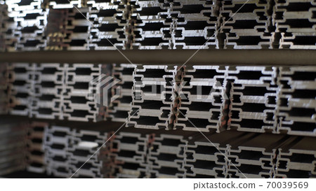 Close up shot of aluminium profiles. Aluminium production line factory warehouse stack of profiles. Heavy metallurgical industrial products, manufacturing business production concept Close up shot of aluminium profiles. Aluminium production line factory warehouse stack of profiles. Heavy metallurgical industrial products, manufacturing business production concept 70039569
