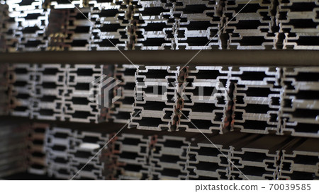Close up shot of aluminium profiles. Aluminium production line factory warehouse stack of profiles. Heavy metallurgical industrial products, manufacturing business production concept Close up shot of aluminium profiles. Aluminium production line factory warehouse stack of profiles. Heavy metallurgical industrial products, manufacturing business production concept 70039585