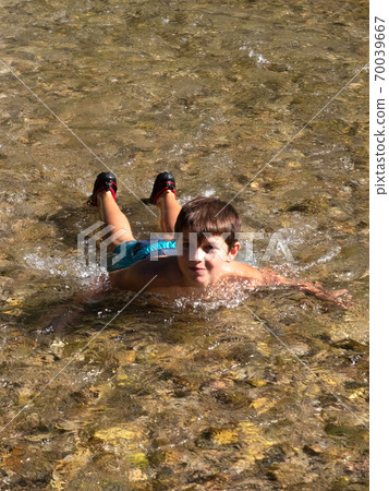 Happy boy having fun swimming in the river water Happy boy having fun swimming in the river water 70039667