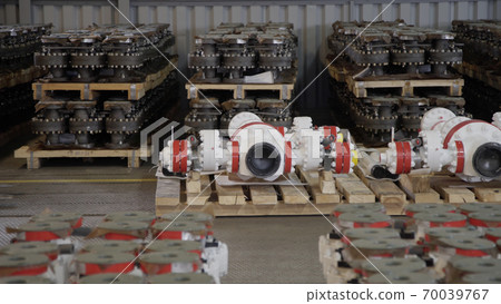 Oil and Gas Wellhead tree equipment production plant on pallets in warehouse. Modern tendencies of machine engineering. Equipment for wellhead conncetion of oil gas wells. 70039767